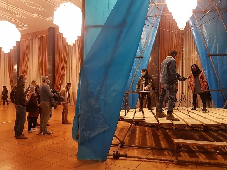 Mohsen Rafei, Chandeliers (2020), lumber, chains, and scaffolding, 13 × 5 × 5 meters. Installation view, Vahdat Hall, Tehran, on the occasion of the 8th National Sculpture Biennial, Iran. Courtesy the artist. — © Courtesy of the artist.