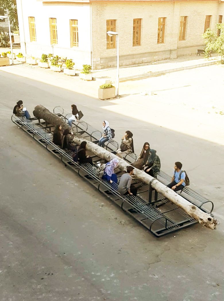 Mohsen Rafei, Jay-be-Jay (metamorphosis) (2019–22), tree trunk and metal, 1.2 × 2.7 × 13 meters. Installation view, Tehran University of Art campus quad. Courtesy the artist. — © Courtesy of the artist.